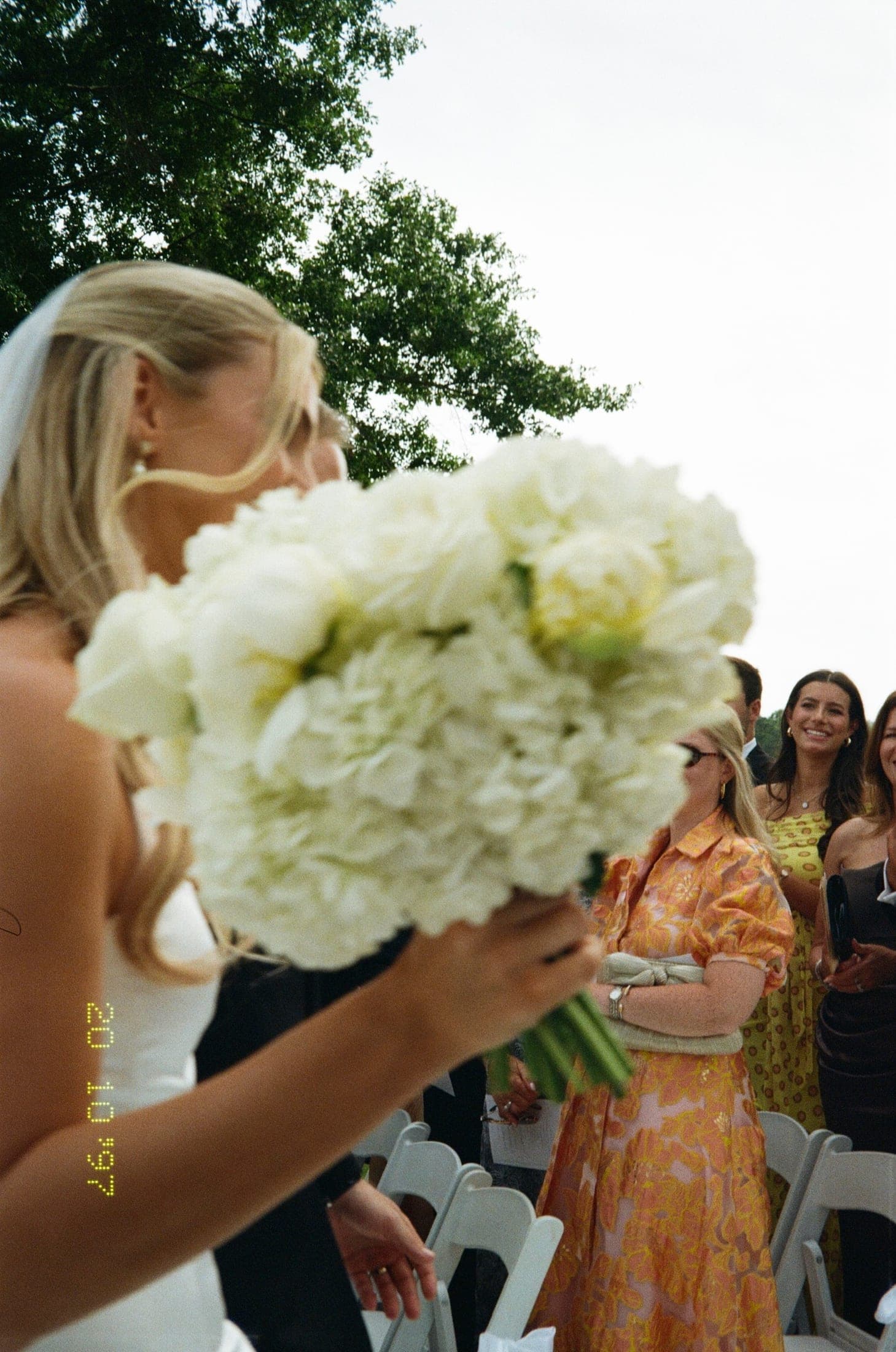 the bride behind her white bouquet