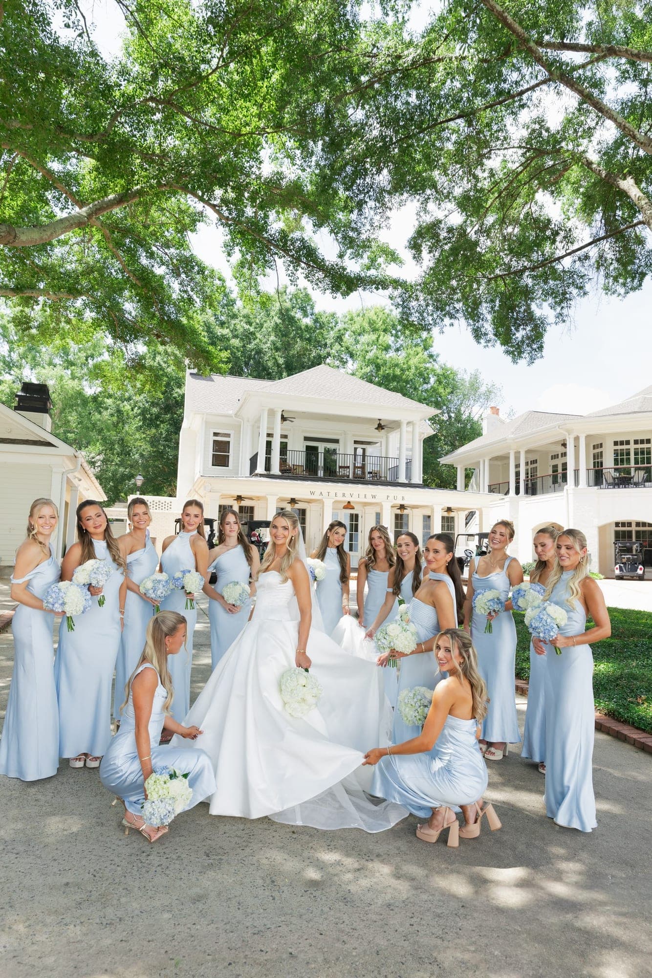 the bridesmaids in pale blue on the lawn
