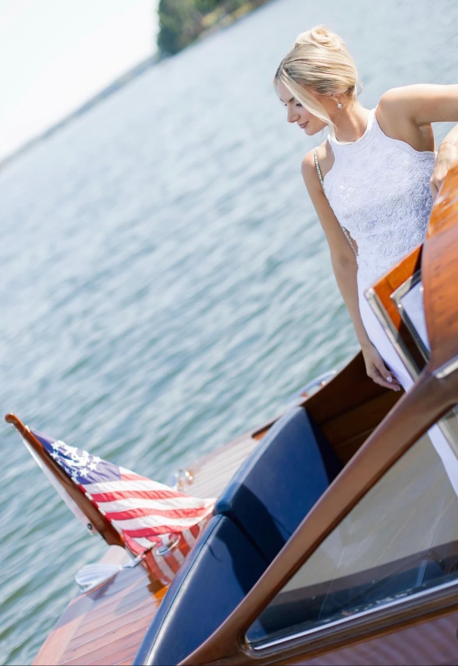 the bride on the bow of a wooden boat on Lake Oconee