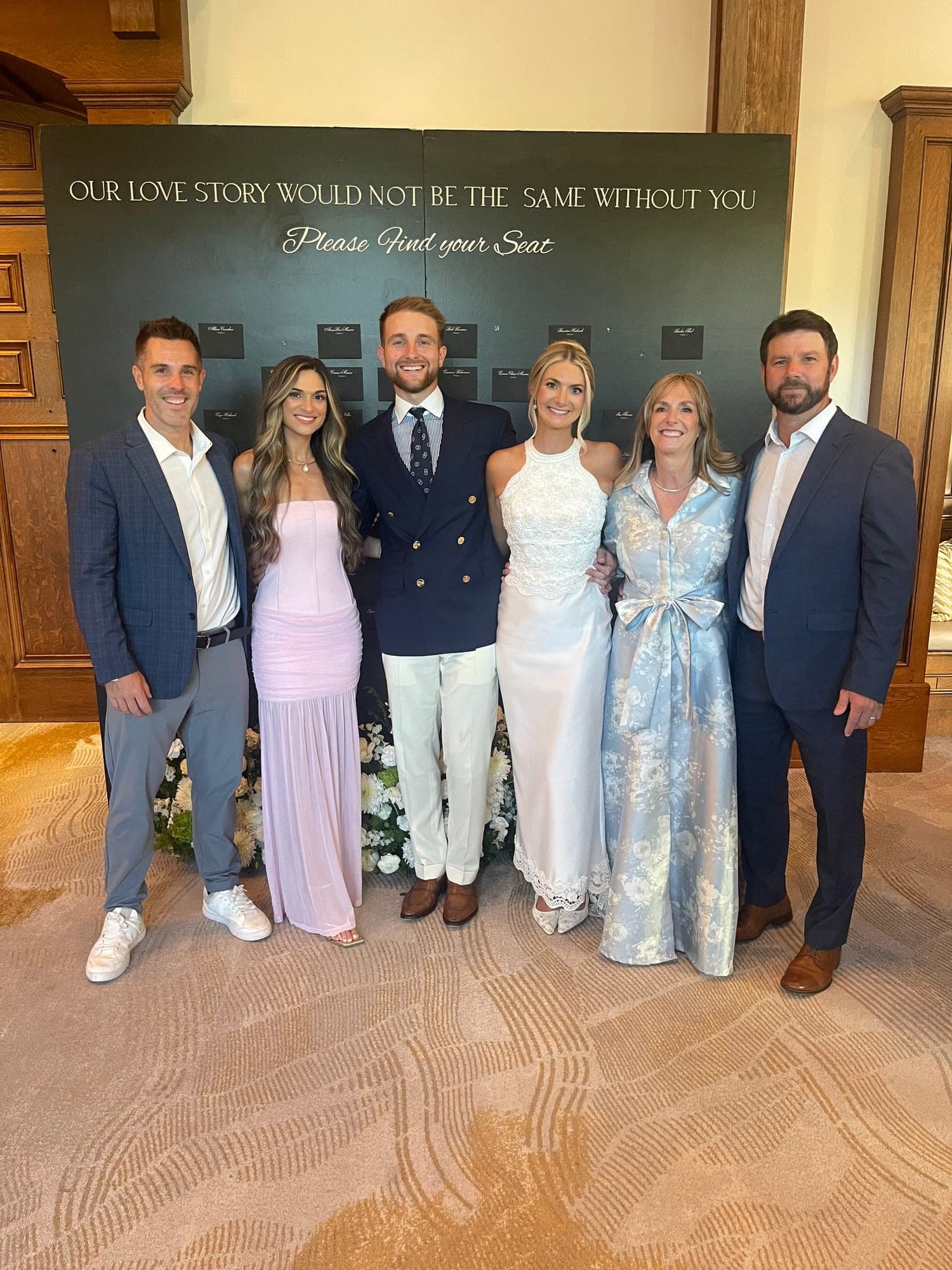 the wedding party gathered at the seating board